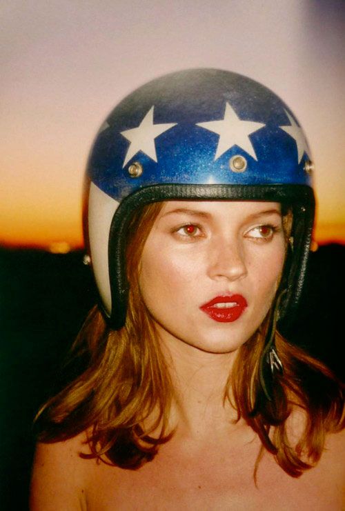 a woman wearing a helmet with stars painted on the side and red lipstick in her lips