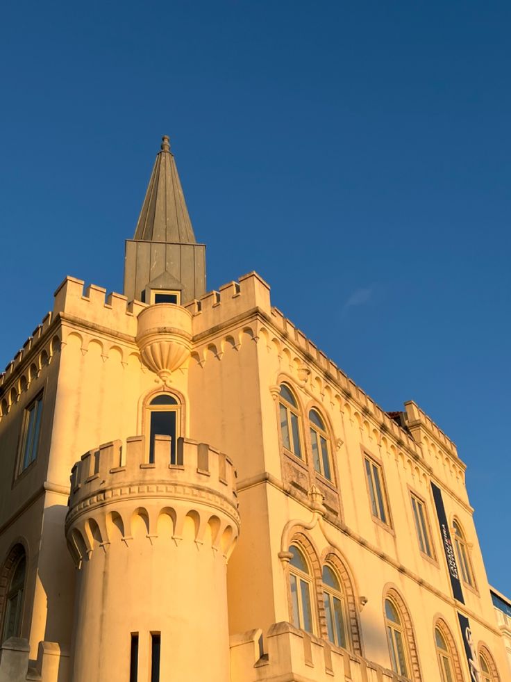 a tall building with a clock on the front of it's face and windows