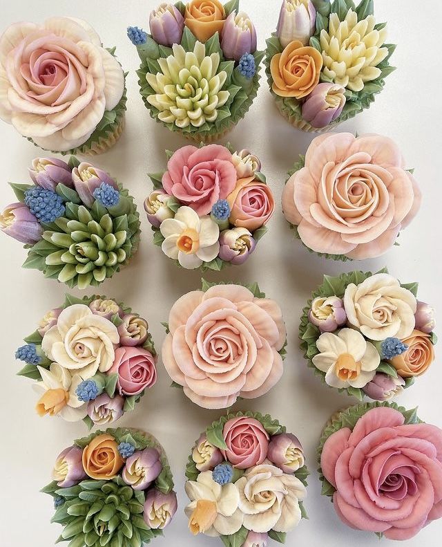 cupcakes decorated with pink and yellow flowers are arranged in the shape of succulents