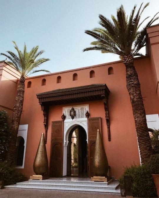 an entrance to a building with palm trees