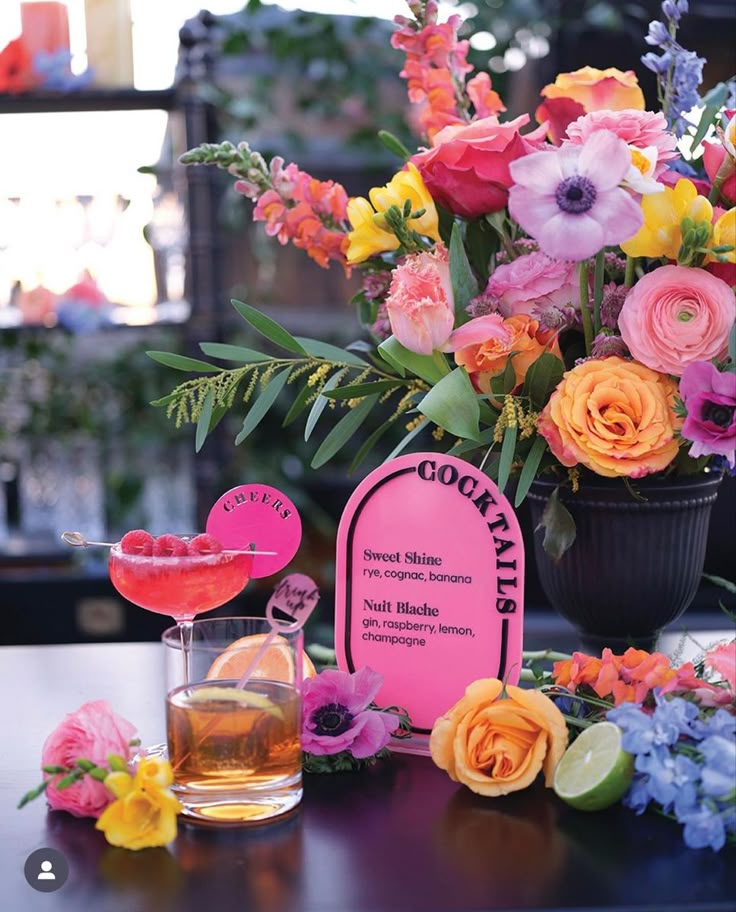 a table topped with flowers next to a glass filled with liquid and a sign that says good friday