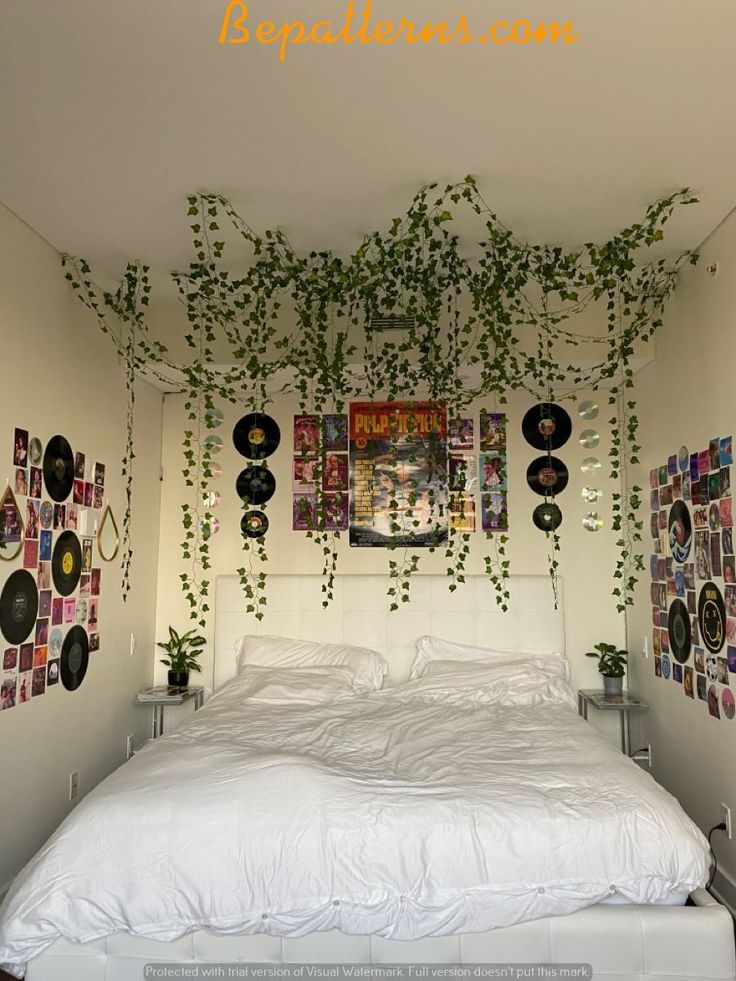 a white bed sitting in a bedroom next to a wall with pictures hanging on it