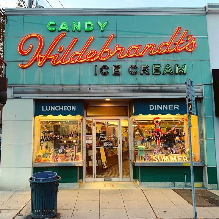 an ice cream shop with neon lights on the front and side of it's storefront