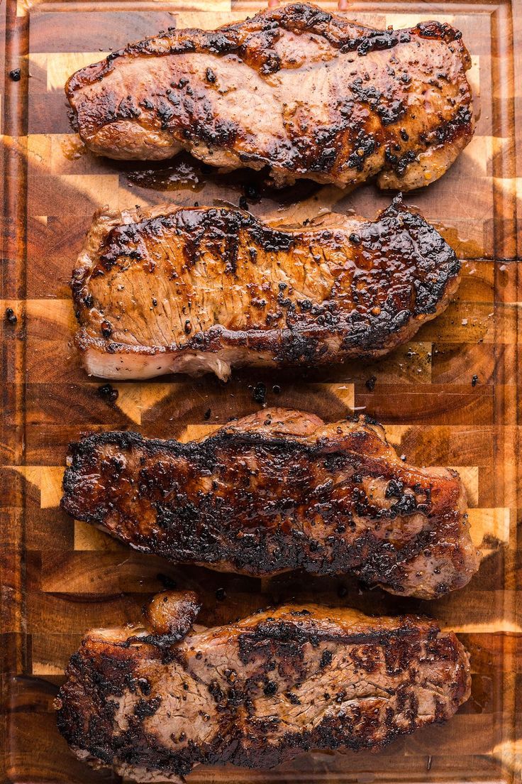 grilled steaks on a cutting board ready to be cooked