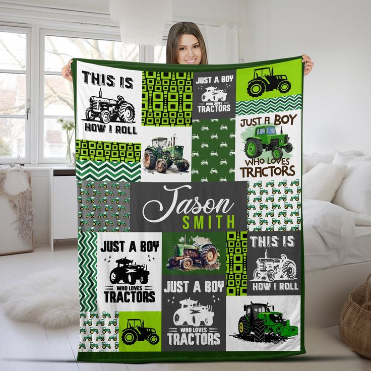 a woman holding up a quilt with tractors on it