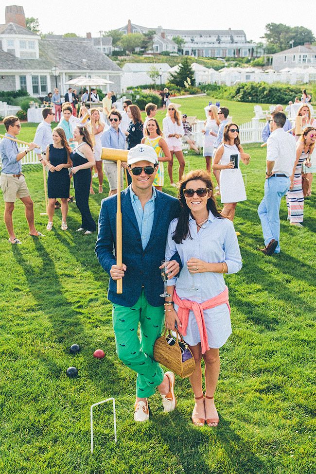 a man and woman standing in the grass with croquets on their feet