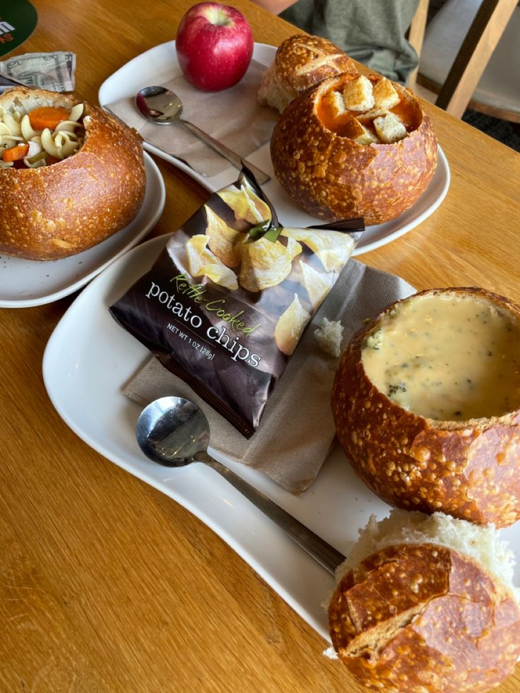 bread bowls filled with soup and apples on a table