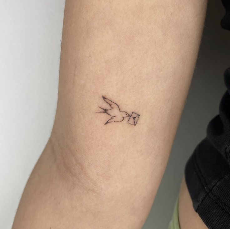 a small bird tattoo on the arm