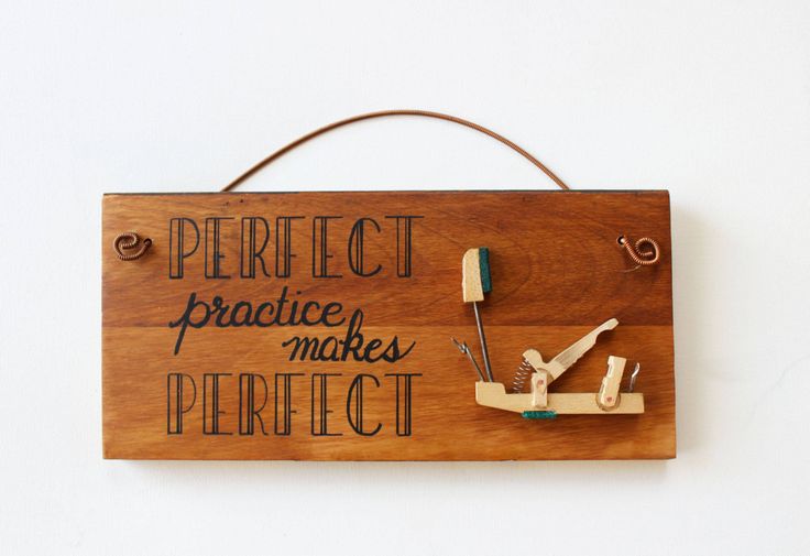 a wooden sign that says perfect practice makes perfect with scissors and pegs attached to it