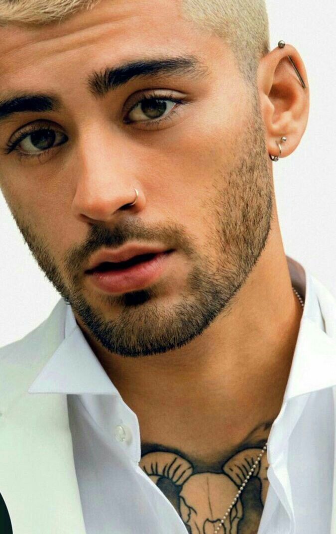 a close up of a person wearing a shirt and tie with tattoos on his chest