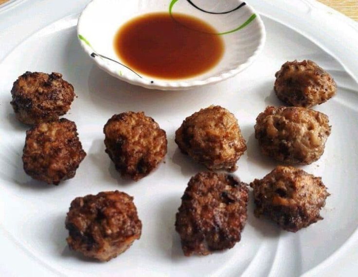 a white plate topped with meatballs and dipping sauce