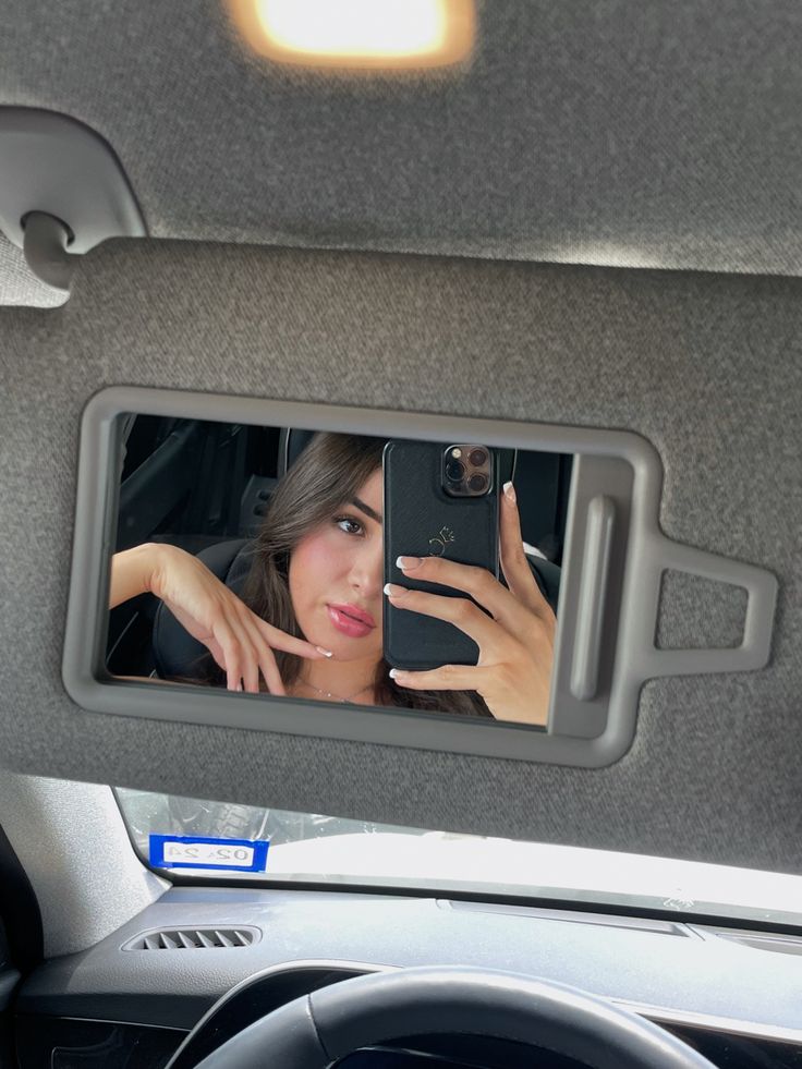 a woman taking a selfie in the back seat of a car