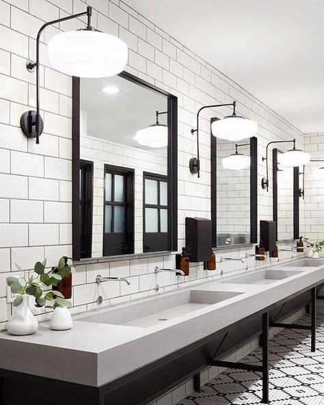 a bathroom with three sinks, mirrors and lights on the wall next to each other