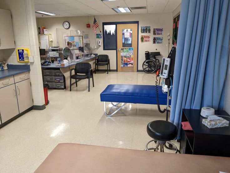 an empty hospital room with blue drapes on the windows