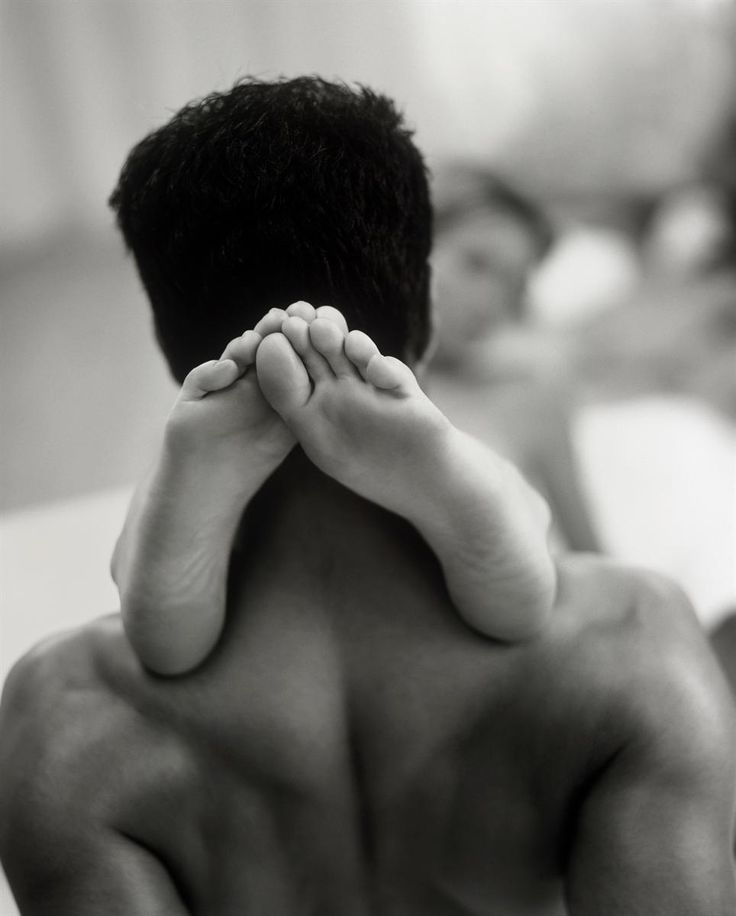 the back of a man's head with his hands resting on his chest and feet