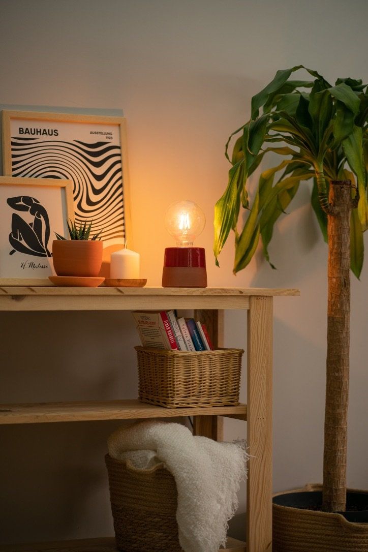 there is a potted plant on the shelf next to two baskets and a candle