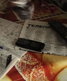 there are many papers and remote controls on the table