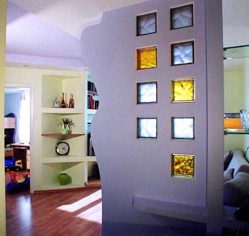 a living room filled with furniture and lots of windows next to a book shelf full of books