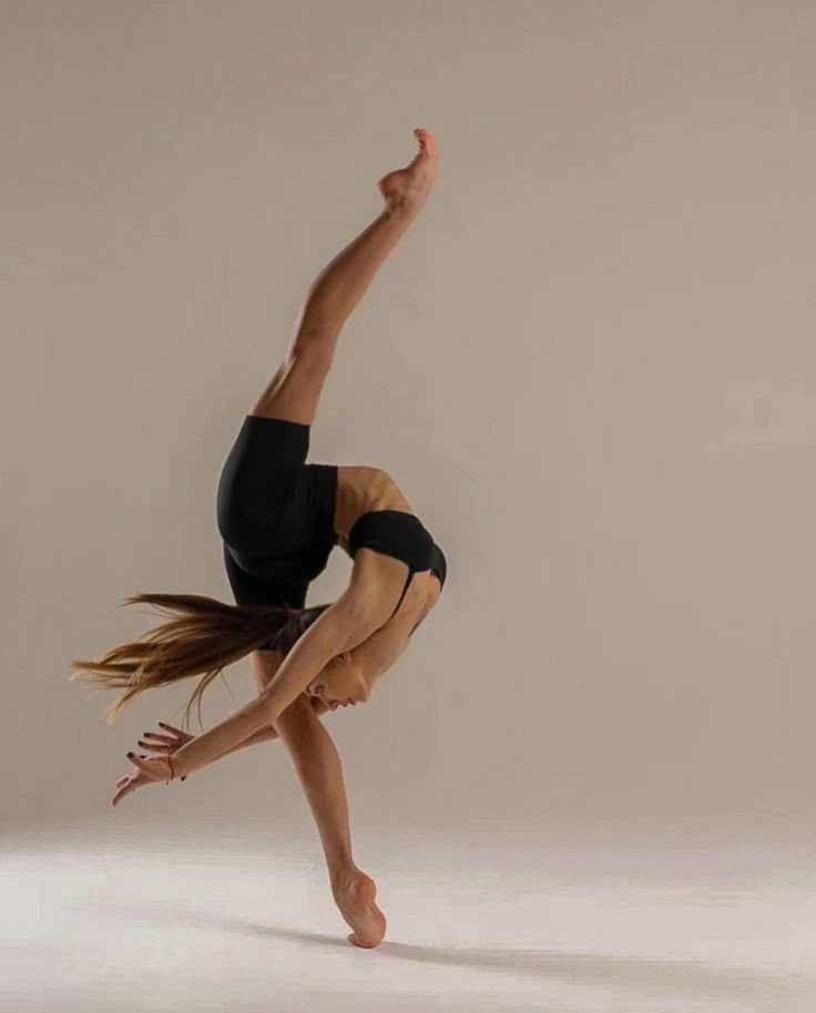 a woman is doing a handstand on one leg