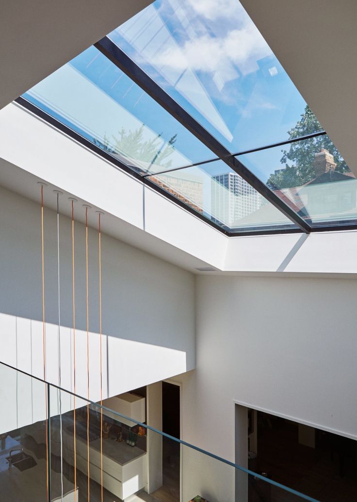 the interior of a modern house with skylights and glass railings on both sides