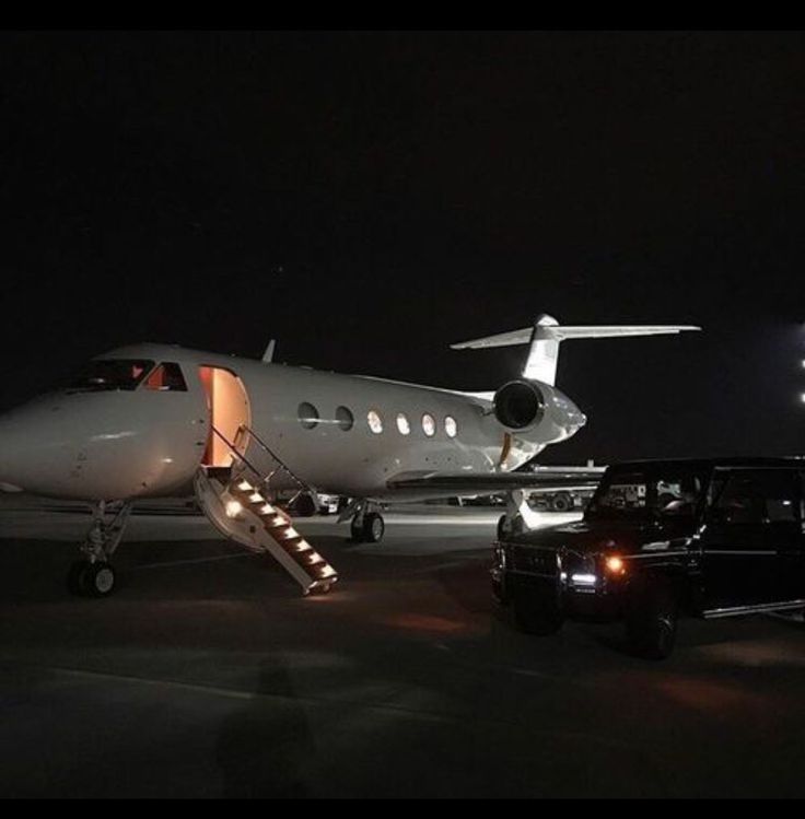 an airplane is parked on the tarmac at night with people walking up to it