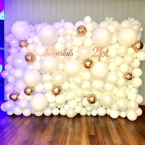 the balloon wall is decorated with white and gold balloons