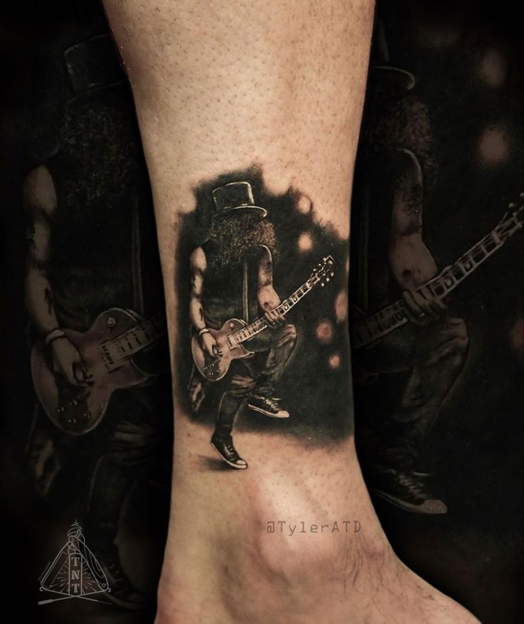 a man with a guitar tattoo on his foot