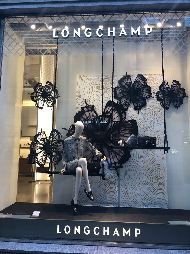 a store window display with black umbrellas hanging from it's glass front windows