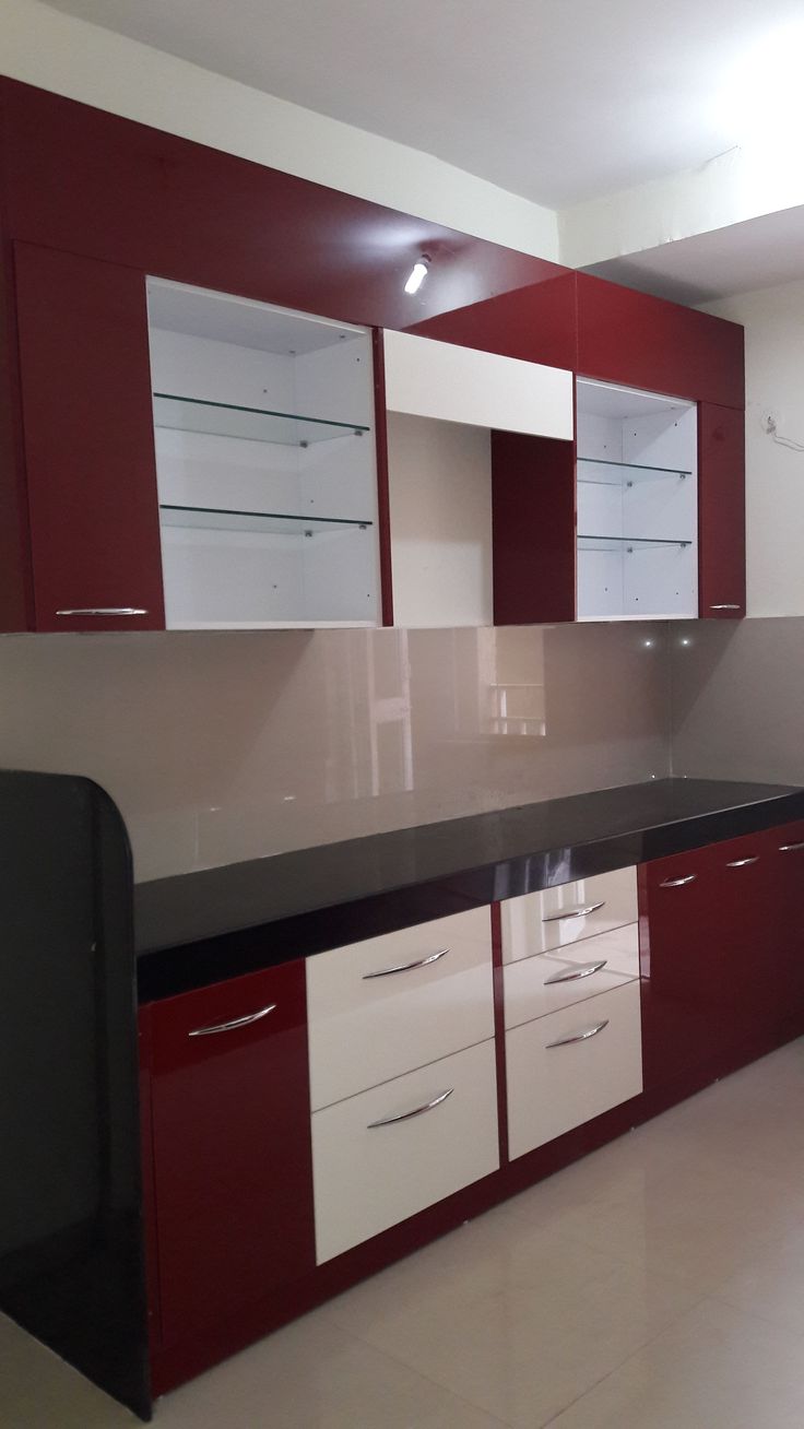 an empty kitchen with red and white cabinets