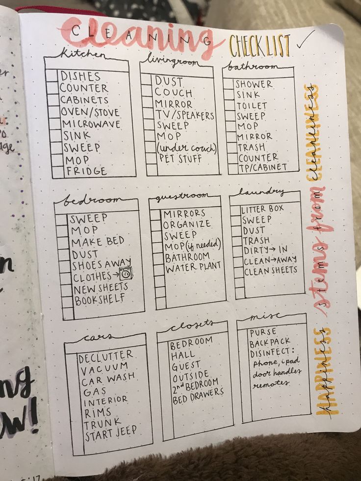 a hand holding up a planner with the words cleaning checklist written in red on it