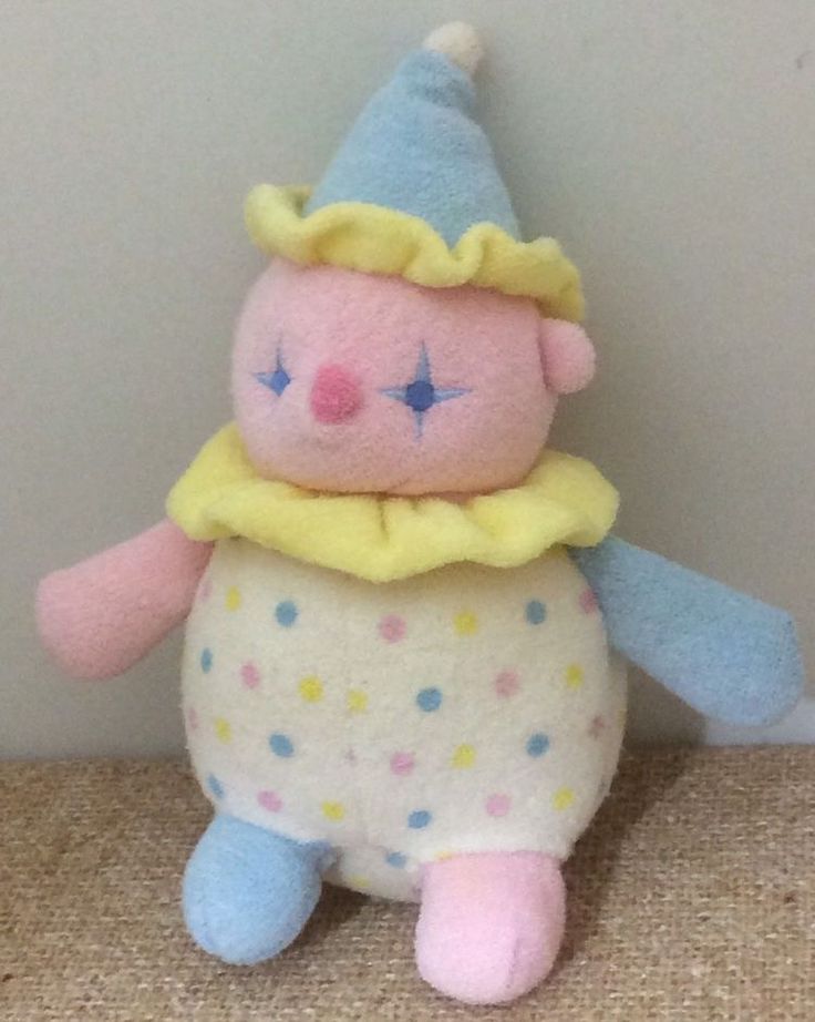 a small stuffed animal with a blue hat and polka dot dress on it's head