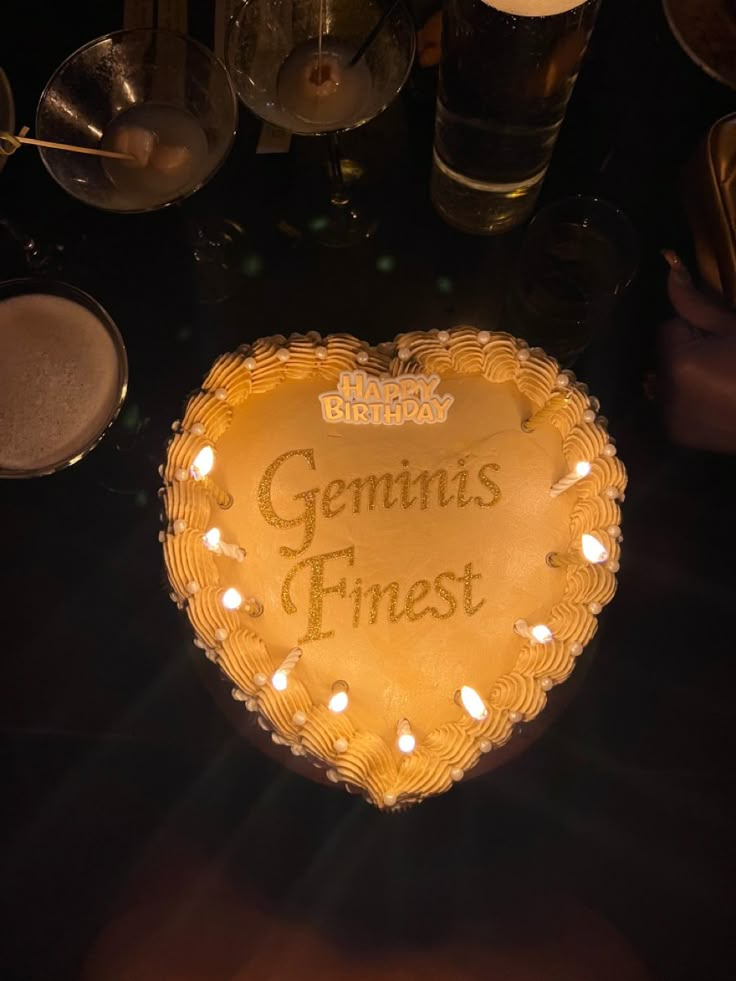 a heart shaped cake sitting on top of a table with lit candles in the middle