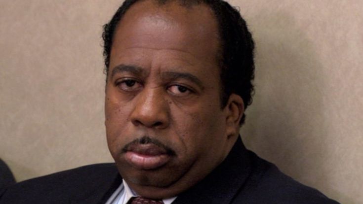 a close up of a person in a suit and tie with a serious look on his face