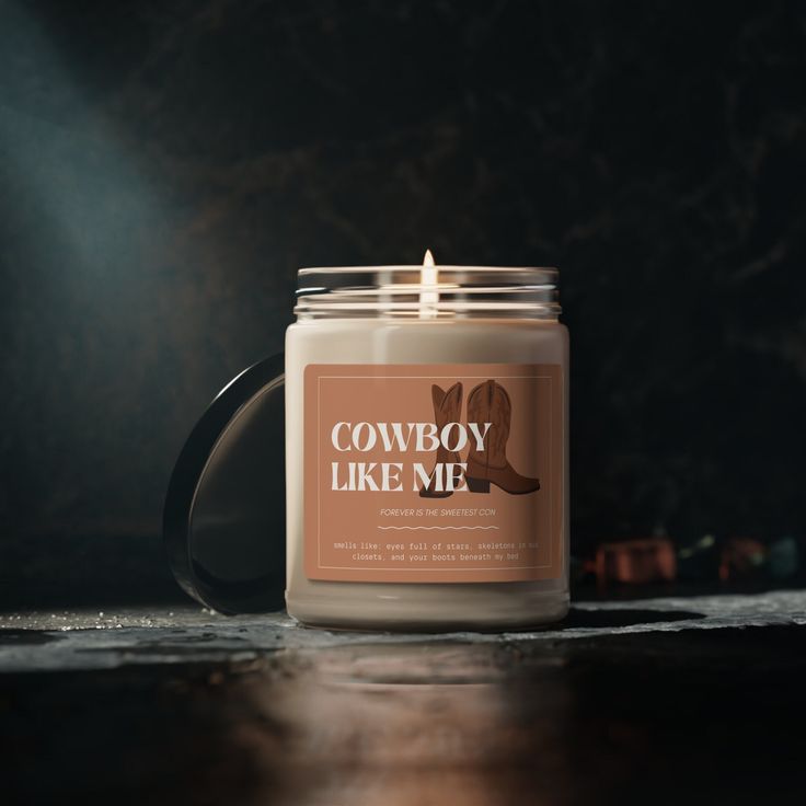 a candle is sitting on a table with the words cowboy like me printed on it