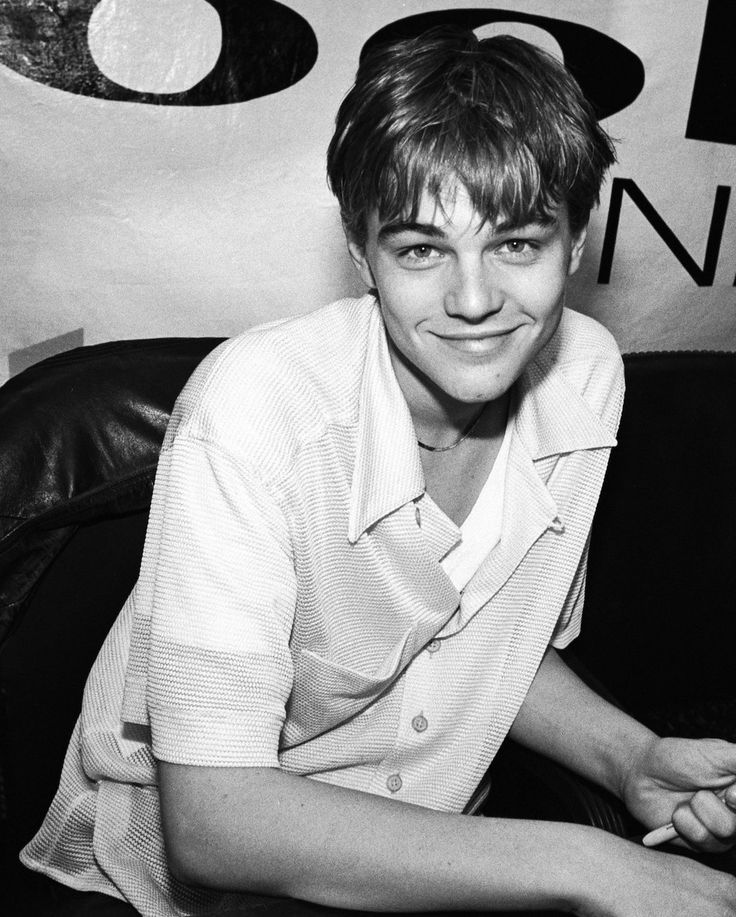 black and white photograph of a young man sitting at a desk with his hand on the keyboard