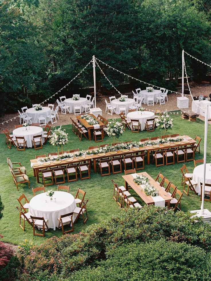 an outdoor wedding reception setup with tables and chairs