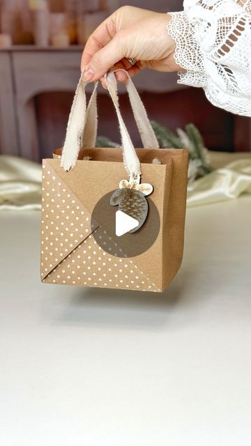 a person holding a brown paper bag with a white polka dot design on the front