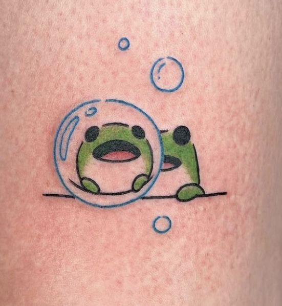 a tattoo with a green frog in a bubble