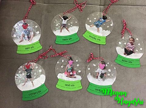 six snow globes with small children in them on a table next to red twine