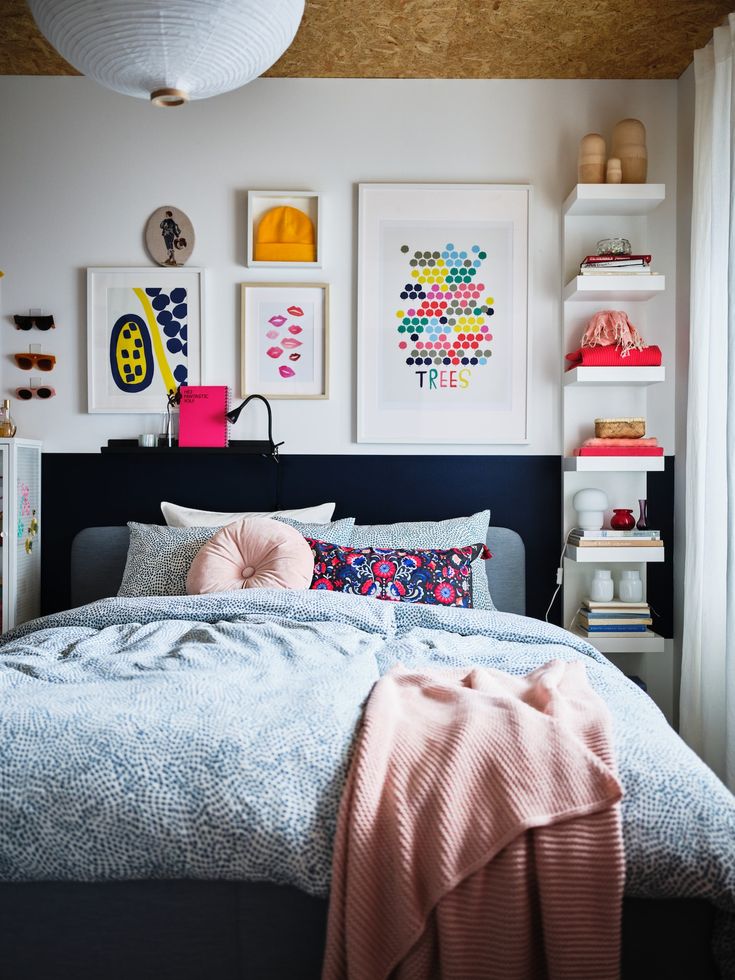 a bedroom with white walls and pictures on the wall