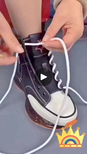 someone is tying up their shoelaces on top of a pair of black and white sneakers