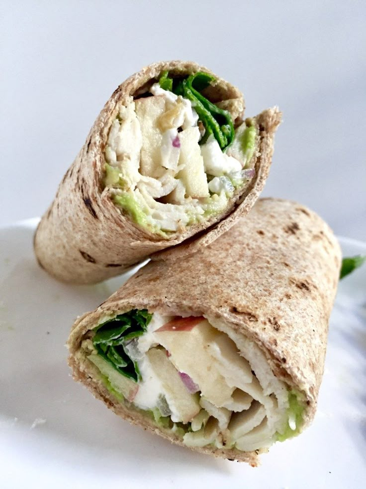 two wraps filled with chicken salad on top of a white plate