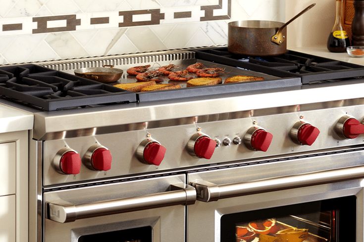 a stove top oven sitting inside of a kitchen next to a counter with food on it