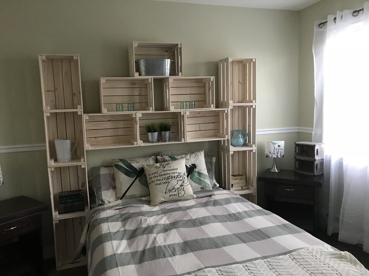 a bed room with a neatly made bed and wooden crates