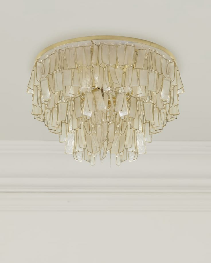 a chandelier hanging from the ceiling in a room with white walls and trimmings