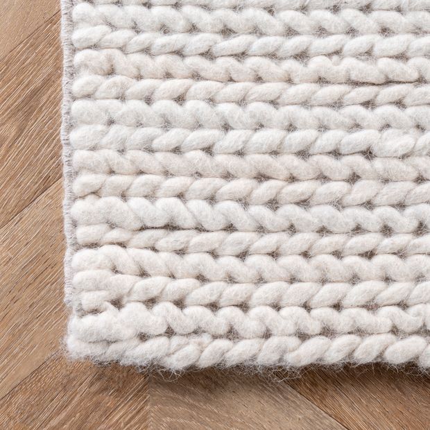 a white rug on top of a wooden floor