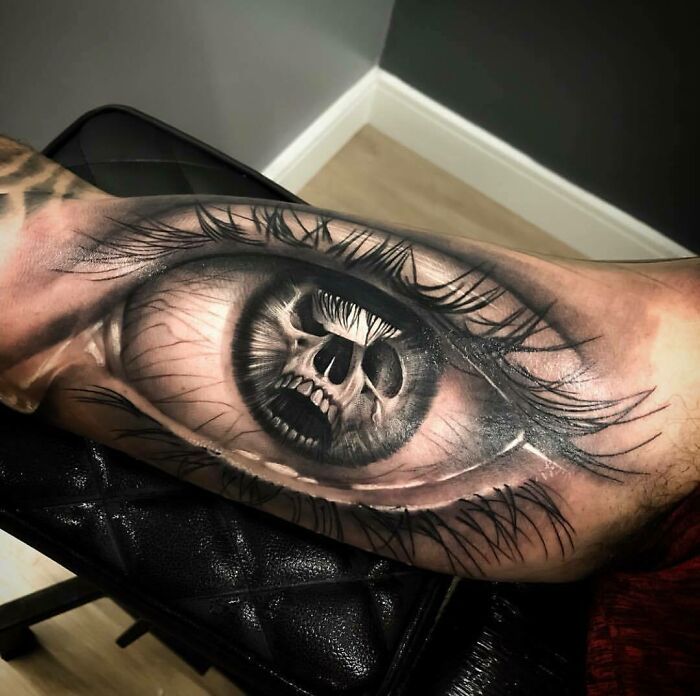 a man's arm with an eye tattoo on it