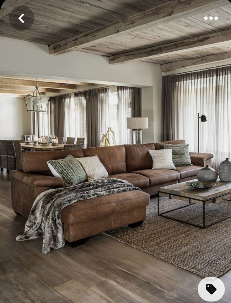 a living room filled with lots of furniture next to a wooden floor covered in windows