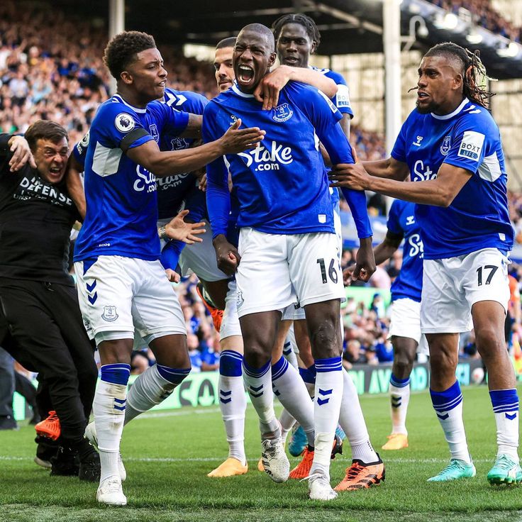 the soccer players are celebrating their team's goal in front of an excited crowd