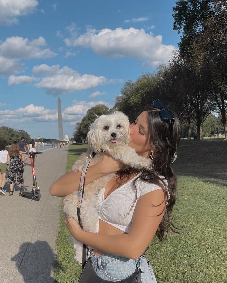 a woman is kissing her dog on the side walk near the lincoln memorial in washington, d c